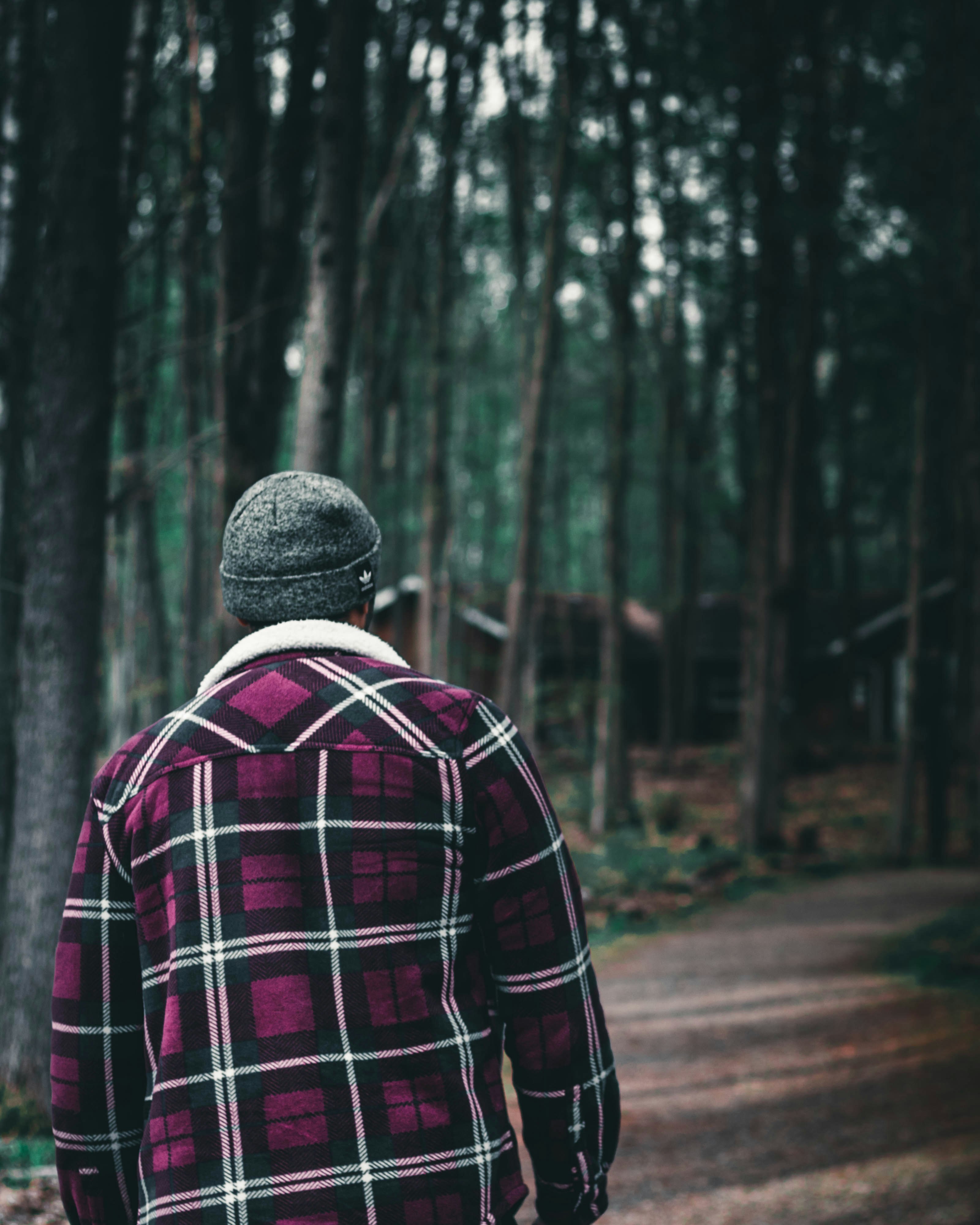 man in red black and white plaid dress shirt standing on road during daytime